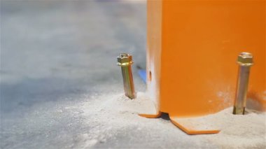 ağır çekim portre işçi bolthole turuncu metal destek altındaki büyük altın çivi çekiç