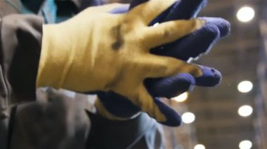 ağır çekim portre işçi mavi-beyaz eldiven ellerini akışı odak metal raflar depo içinde karşı gürlemesi