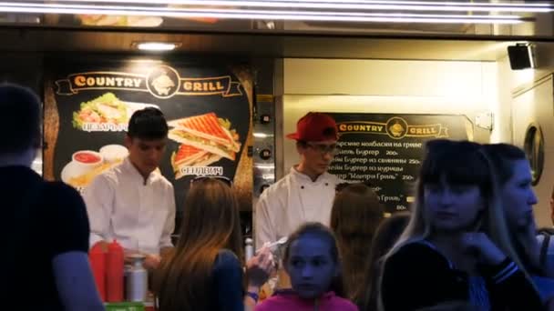 カザン タタールスタン共和国 ロシア連邦 2017 子供を持つ人々 を食べるし 料理人はカザンの 日モール広場においしいファストフードを調理のテントで注文を取る — ストック動画