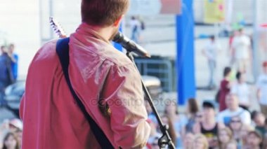 Kazan, Tataristan/Rusya - 07 Kasım 2017: Gitar ile tişörtlü arka görünümü adam şarkı konser sahne ve müzik hayranları arka planda üzerinde 07 Kasım kazan söyler