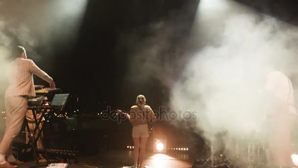 俄罗斯 2017年11月03日 背面看白色短裤中的金发女郎演奏电吉他表演与乐队成员在台上在11月03日在喀山 — 图库视频影像