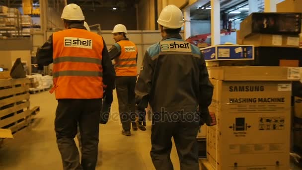 俄罗斯 2017年10月25日 慢动作工作者组货架标志制服在10月25日在喀山的大仓库里走过去的托盘和箱子 — 图库视频影像