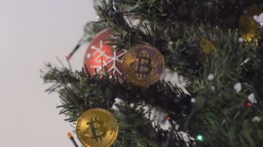 Altın bitcoins ve garland yağan kar ile süslenen closeup tatil Noel ağacı ön plan üzerinde