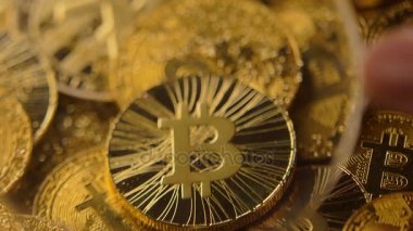 makro büyüteç yukarıda parlayan altın sikke yığın bitcoin değerli bir kaynak tarafından yapılan kişi eliyle