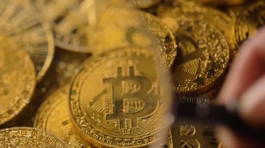 Makro görünümü büyüteç ile masaya döşeme harika parlayan bitcoin gerçek model yığın üzerinde