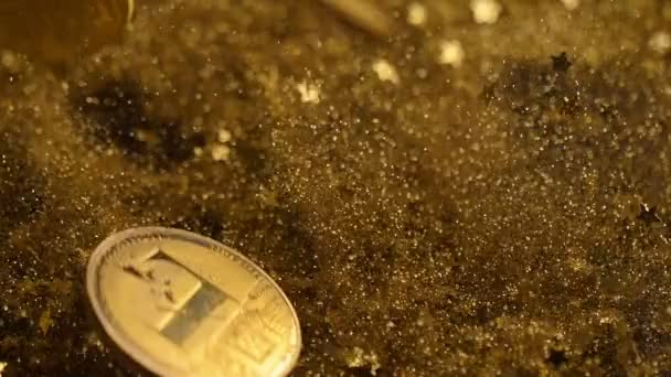 Cryptocurrency 真实模型硬币在美丽的闪闪发光的金黄尘土之中跌倒和跳跃 — 图库视频影像
