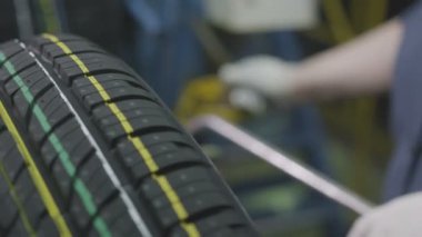 Fabrika kadın çalışan eldiven bitmiş kauçuk lastik atölyesinde işaretlemek için dönen ekipman yönetir
