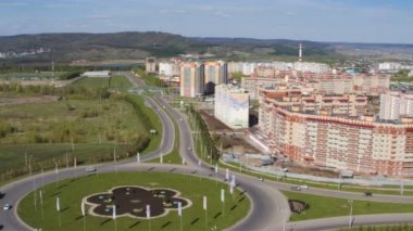 Kamera yukarıda yeni konut bölgesi kavşağında yuvarlak Rating mavi gökyüzü karşı sonsuz yeşil çayırlar sinekler