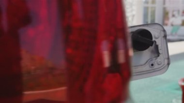 araba kırmızı arka ışık Oto gaz tankı benzin istasyonunda silah koyarak teknisyen için kenara closeup hareket