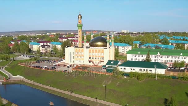 Flycam 显示美妙的老白色墙壁清真寺与闪耀的金子圆顶在绿色堤反对蓝天 — 图库视频影像