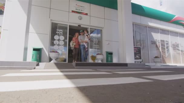 カザン タタールスタン共和国 ロシア連邦 2017 石油駅から出てくる笑顔の家族および父 日カザンの車両に歩いて腕の中で娘を保持します — ストック動画