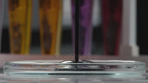 マクロ ブラック原料油いっぱいガラス研究室キャップと背景の明るい色の液体の試験管 — ストック動画