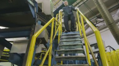 Kazan, Tataristan/Rusya - 25 Aralık 2017: Kalifiye teknisyen metal merdiven gider ve büyük konveyör mekanizması ile lastik kauçuk şerit üzerinde 25 Aralık kazan kontrol eder