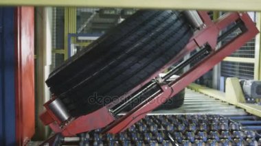 Kazan, Tataristan, Rusya Federasyonu - 12 Eylül 2017: ağır çekim kırmızı metal robot mekanizması renkli işaretleri ile lastik koruyucu Konveyör bant üzerine koyar 