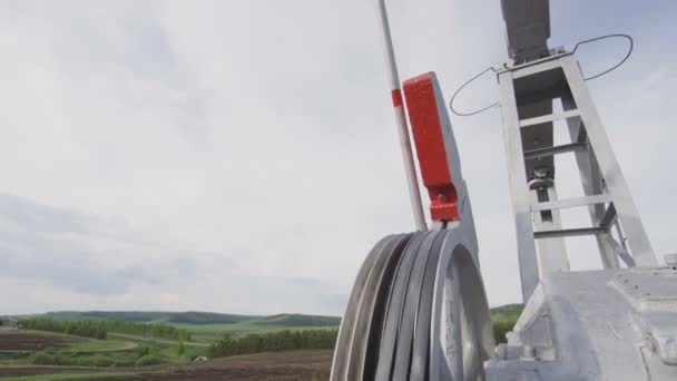 ベルトの大きなホイールのクローズ アップが回転し 曇り空を背景に油田の移動ポンプ ジャック マシンを作る — ストック動画