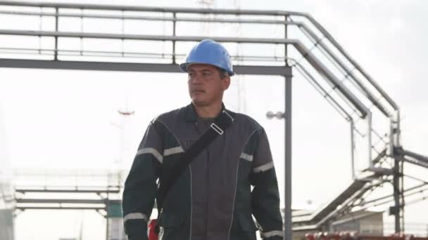 カザン タタールスタン共和国 ロシア連邦 2017 若いエンジニアが歩くし 日カザンの現代ガス精製工場面積パイプラインと白のタンクの周りに見える — ストック動画