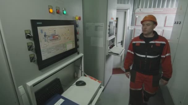 Инженер приходит на панель управления с современным дисплеем — стоковое видео