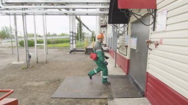 Kazan, Tataristan/Rusya - 08 Ağustos 2017: Adam kıyafeti gürültülü atölye alır kask kapalı geliyor ve ekipman üzerinde 08 Ağustos kazan kontrol etmek için koruyucu kulaklık koyar