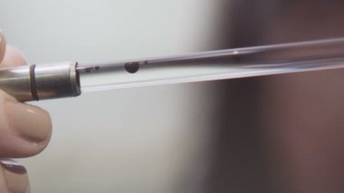 temiz su içinde dar laboratuvar cam metal ipuçları ile tayin closeup küçük siyah ham petrol düştü