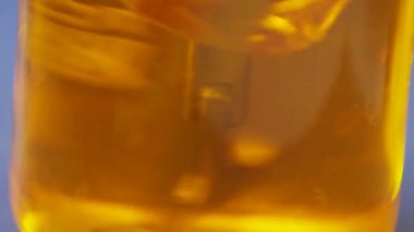 makro test laboratuvar cam mavi masada metal parça yuvarlak çevirerek karışık sarı saydam madde ile