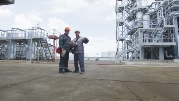 Män ser på papper bland Gas distribution Station — Stockvideo