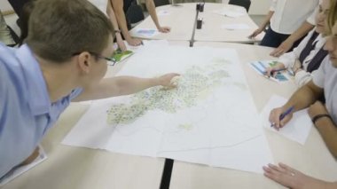 Kazan, Tataristan/Rusya - 22 Ağustos 2017: Yan görünümü genç profesyonel mühendis arkadaşları yeni anket Servisi yerler Office büyük harita üzerinde 22 Ağustos kazan gösterir