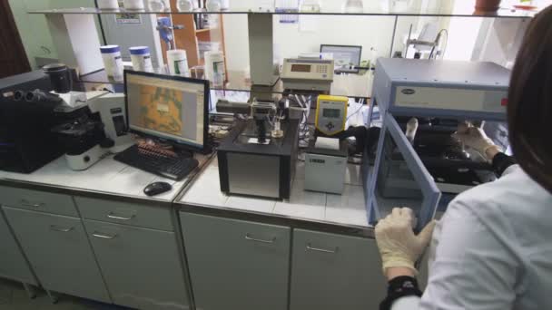 クローズ アップ裏面表示の若い女性がカザンで 日に研究室での化学装置に液体ガラスを置くカザン タタールスタン共和国 ロシア連邦 2017 — ストック動画