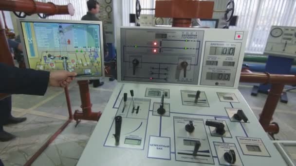 オフィス スーツの中年エンジニアは 日カザンの工場会議ホールで訪問者に現代制御パネルを示していますカザン タタールスタン共和国 ロシア連邦 2017 — ストック動画