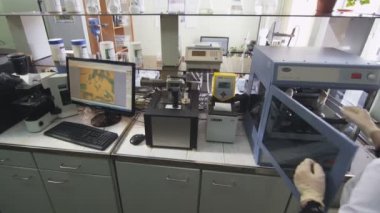 Kazan, Tataristan/Rusya - 23 Ağustos 2017: Arka üst görünüm koyu saçlı kadın asistan ampul yağı ile cam test çalışması koyar ve 23 Ağustos kazan üzerinde izlemek için yürüyor