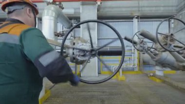 Kazan, Tataristan/Rusya - 19 Eylül 2017: Arka görünümü çalışan yeşil üniformalı kolu gaz rafineri tesisi ardışık düzenindeki yuvarlak 19 Eylül kazan açar