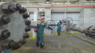 Kazan, Tataristan/Rusya - 19 Eylül 2017: Yeşil üniforma atölye gaz boru hattı üzerinde büyük kolu yuvarlak üzerinde 19 Eylül kazan dönüm içinde çalışan kamera taşır