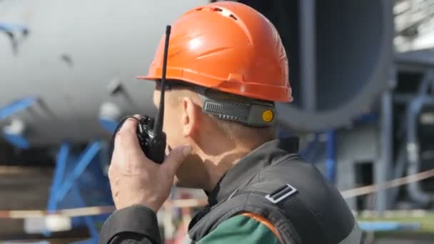 クローズ アップ ワーカーがラジオで話していると 日カザンの工場地域で石油タンクの近くに立って同僚と協力してカザン タタールスタン共和国 ロシア連邦 2017 — ストック動画