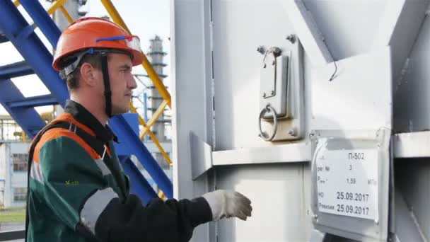 俄罗斯 2017年8月22日 年轻的工程师在头盔与十字体袋检查现代天然气炼油设备在生产塔上8月22日在喀山 — 图库视频影像