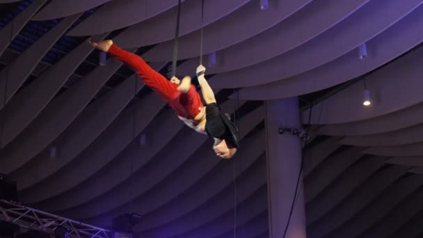 カザン タタールスタン共和国 ロシア連邦 2018 熟練した体操ショッピング モールのサーカス ショーで天井の下でロープで空中の驚くべきトリックを作る — ストック動画