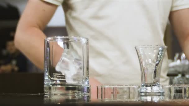 酒保穿着白色 在咖啡馆里把冰块放进玻璃杯里 倒着昂贵的威士忌 — 图库视频影像