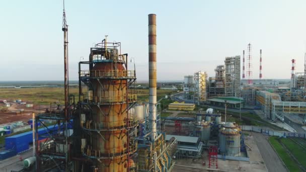 大きな金属製のタンクのラインと石油製油所工場領土白い雲と空を背景に高い塔の空撮 — ストック動画