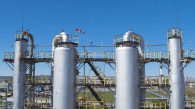 hatları ve yüksek kuleleri petrol rafineri tesisi topraklarında beyaz bulutlar gökyüzü karşı büyük metal tankları