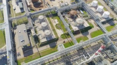 hatları ve yüksek kuleleri petrol rafineri tesisi topraklarında beyaz bulutlar gökyüzü karşı büyük metal tankları