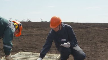 Kazan, Tataristan / Rusya - 17 Nisan 2018: Kasklı kapanış işçisi maden arama çukuruna bakar ve 17 Nisan 'da Kazan' da keşif yapmak için listeye notlar alır