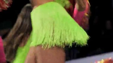 Parlak yeşil etekli seksi kızlar stadyumda dans ediyorlar.