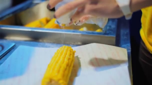 Woman pours boiled sweet corn with salt in fastfood cafe — Stock Video