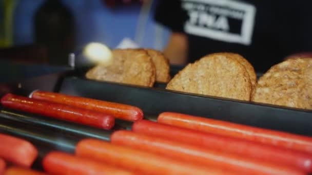 Person takes sausages and patties from grill in cafe closeup — Stock Video