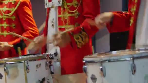 Musicians in red military jackets play drums in room closeup — Stock Video