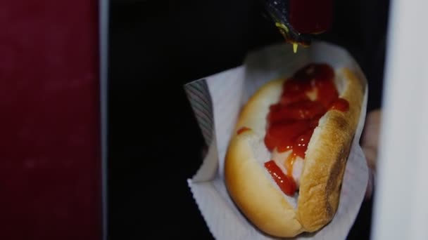 Verter mostaza sobre perrito caliente con salchicha en primer plano de la cafetería — Vídeo de stock