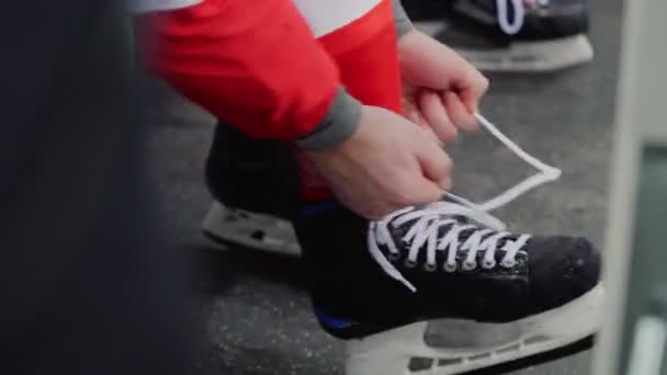 Jugador de hockey cordones skate sentado en el banco vista de cerca — Vídeo de stock