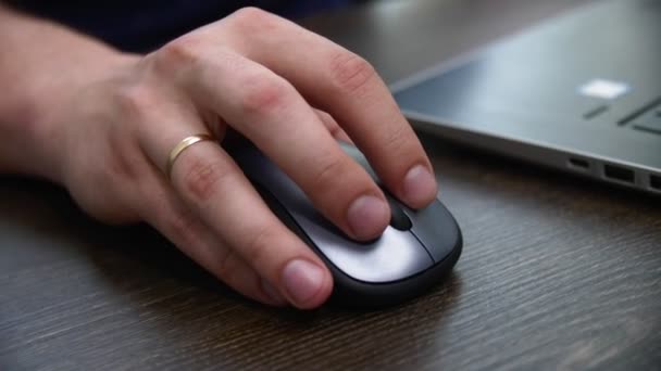 Man werkt op laptop met behulp van draadloze muis op tafel closeup — Stockvideo