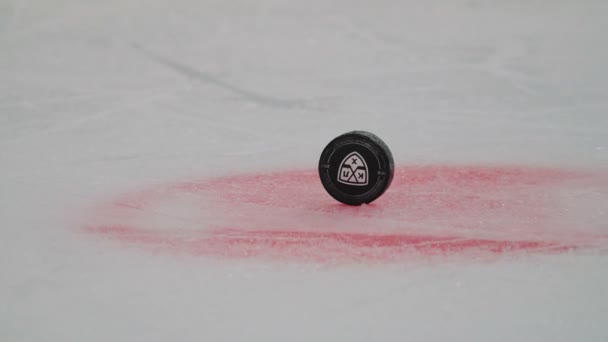Hockey puck with logo in center of arena on stadium closeup — ストック動画