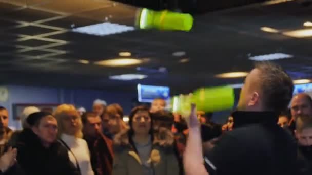 Man joggles bottles entertaining people in stadium hall — Stock Video