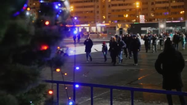 Mensen lopen langs stadsplein voorbij dichte kerstboom — Stockvideo