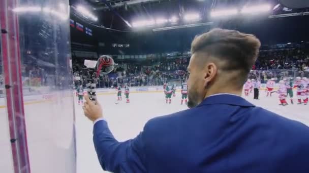 Jornalista com microfone no jogo de hóquei em grande arena de gelo — Vídeo de Stock